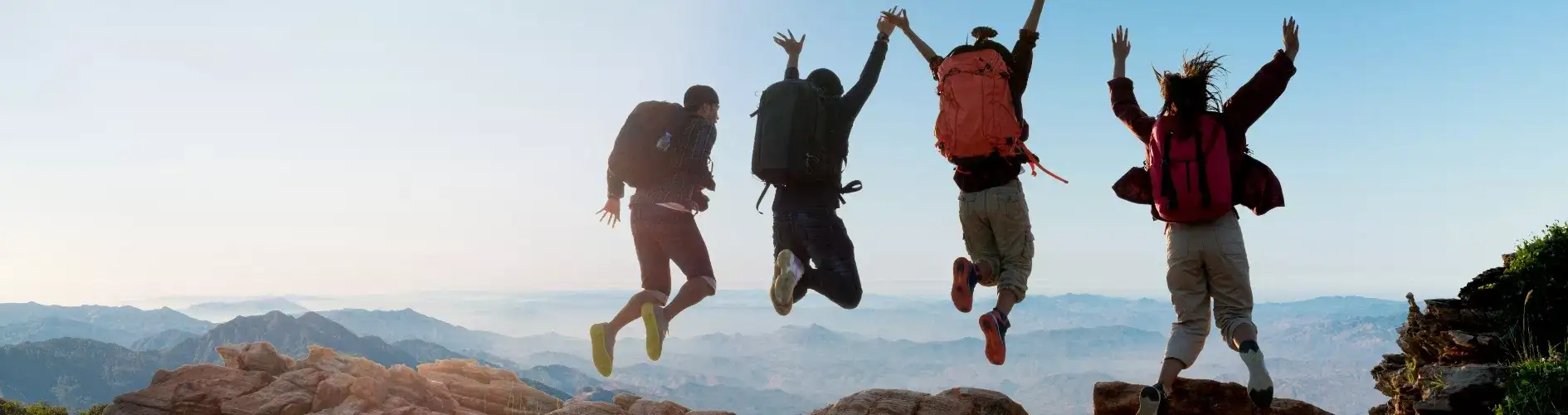 na szczycie góry osoby podskakujące z radości